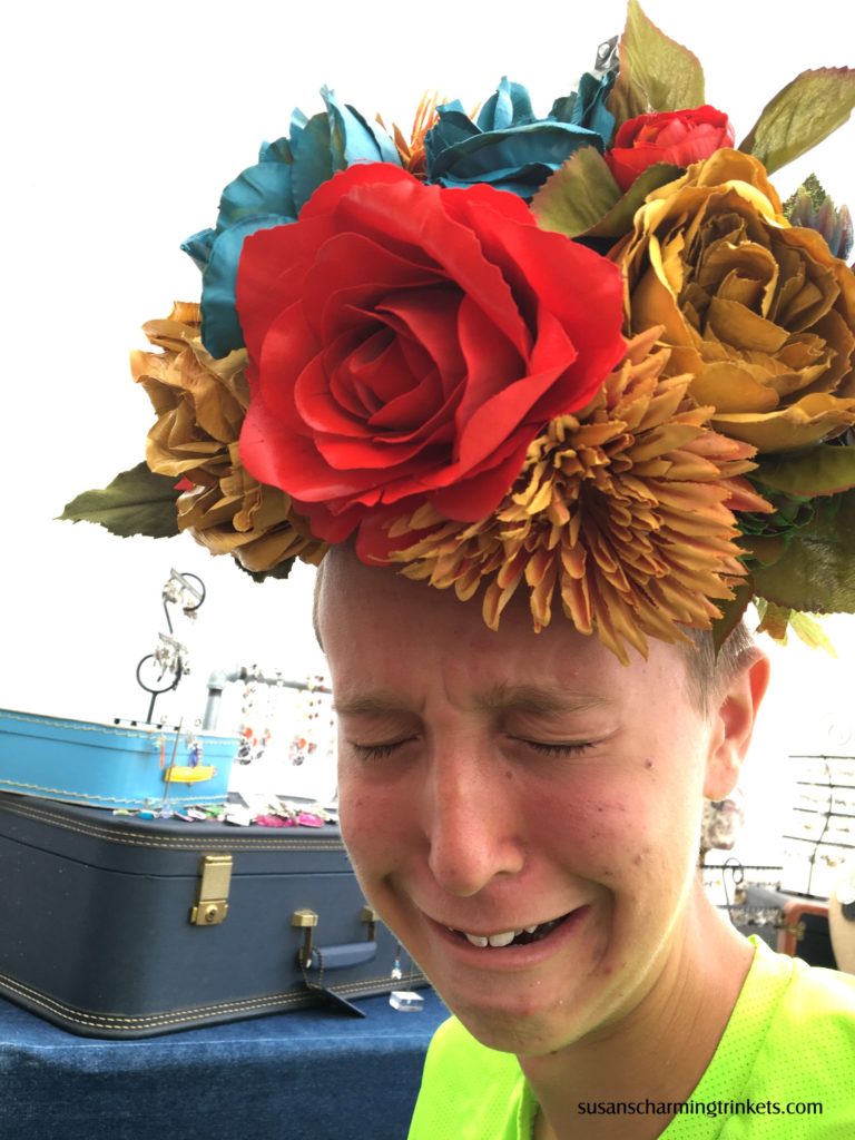 Son is forced to wear flower hat at art show
