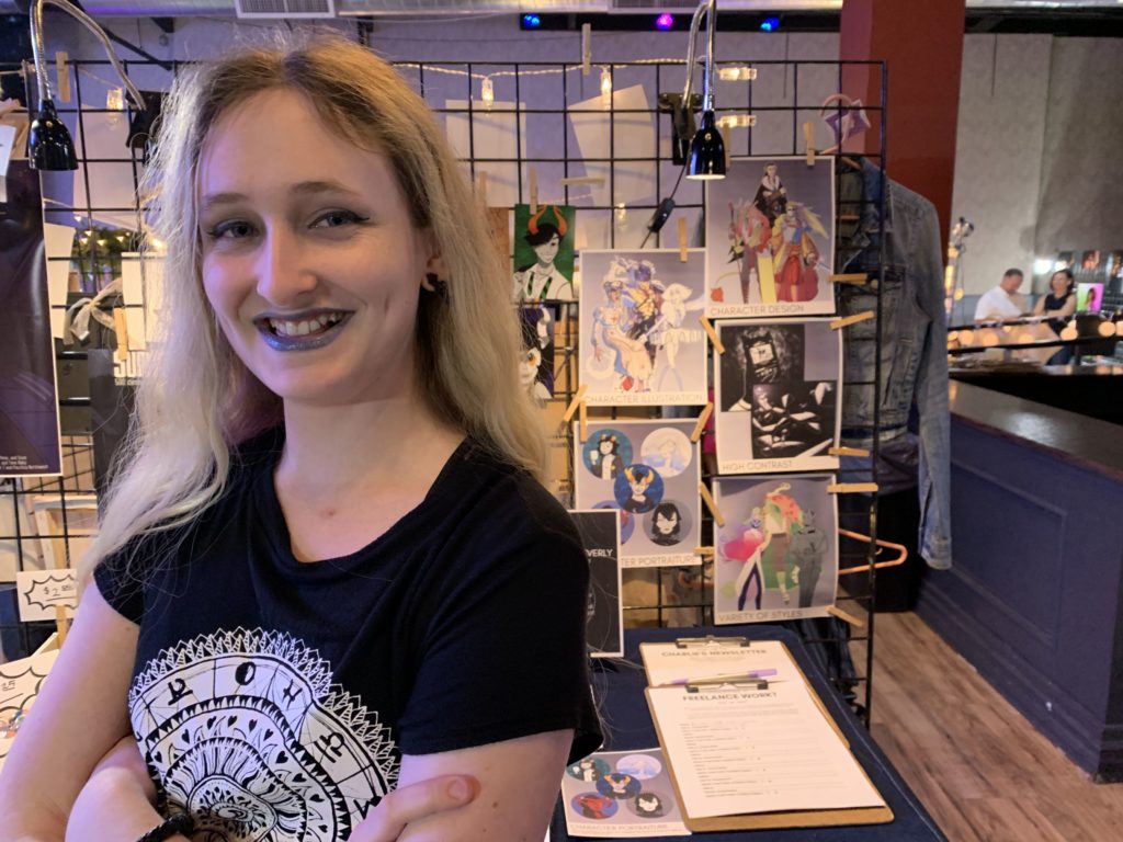 My blonde daughter at her first art show in front of her booth
